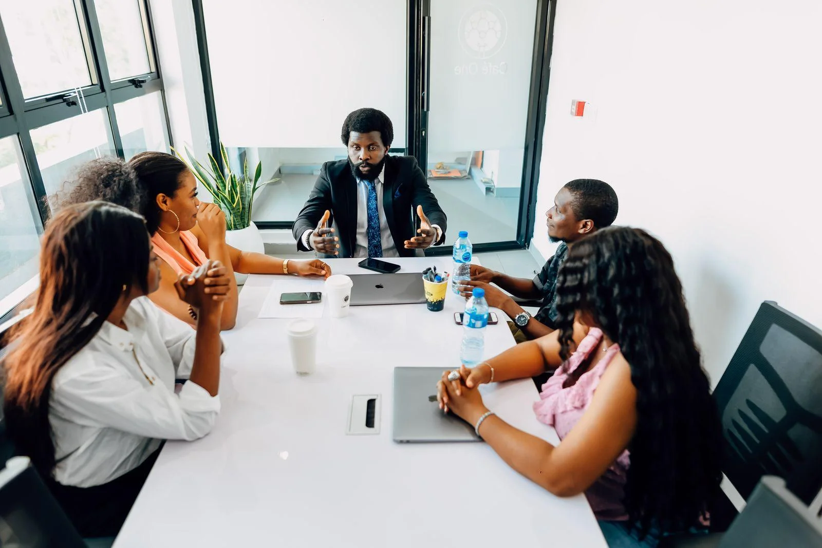 Colleagues discuss their work around a meeting table in a Lagos office